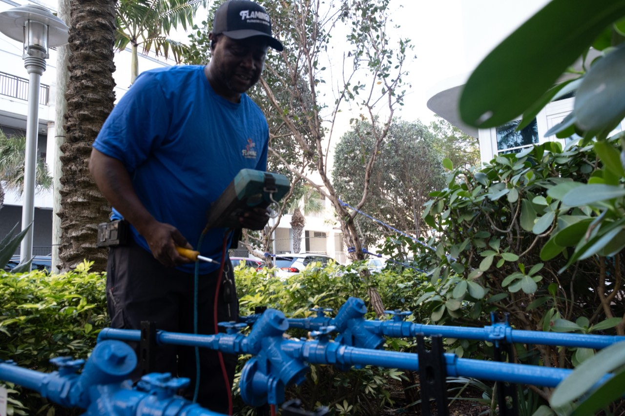 Flamingo Plumbing technician with a test gauge kit on a South Florida job site