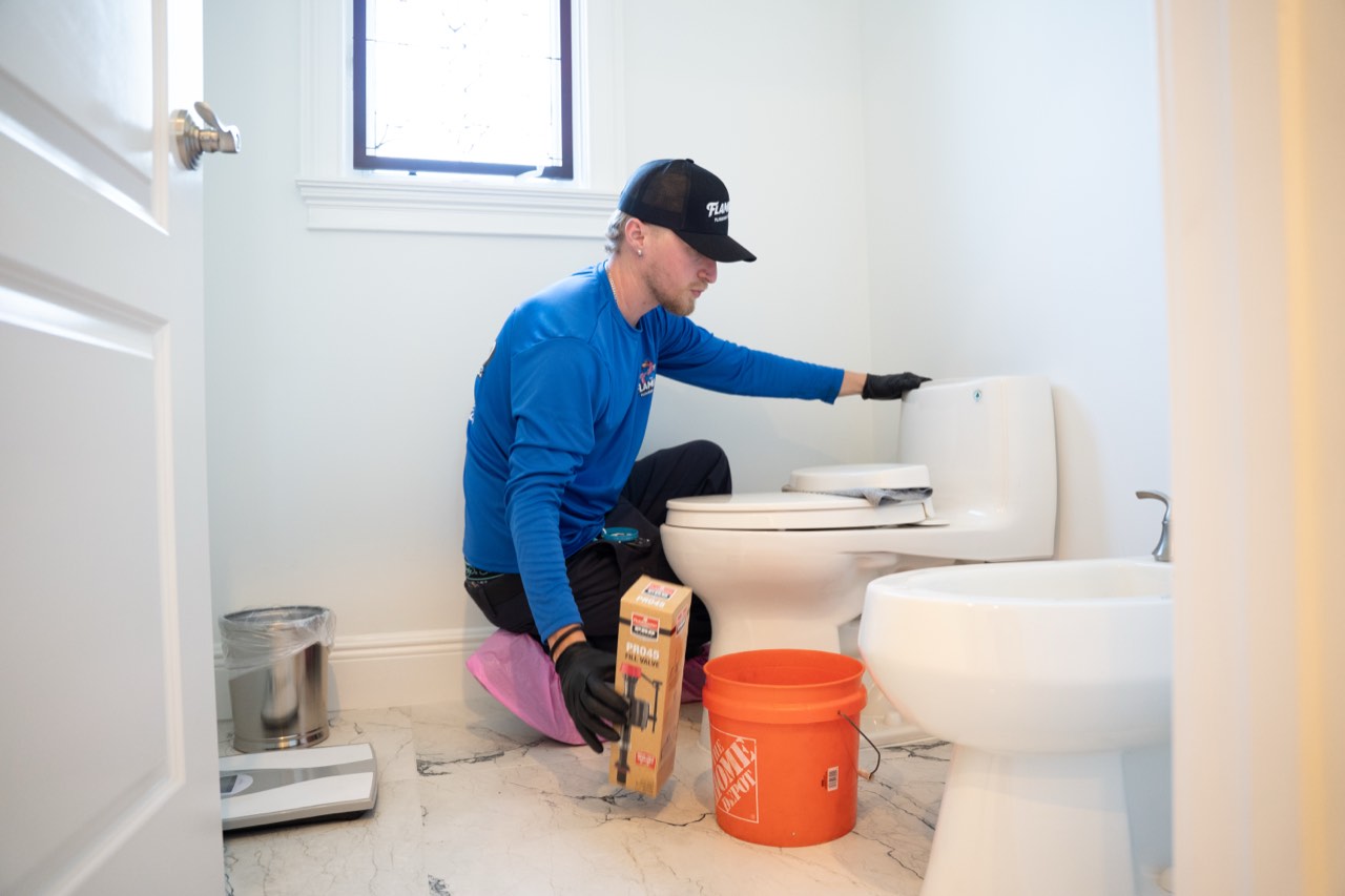 Flamingo technician repairing a toilet fill valve