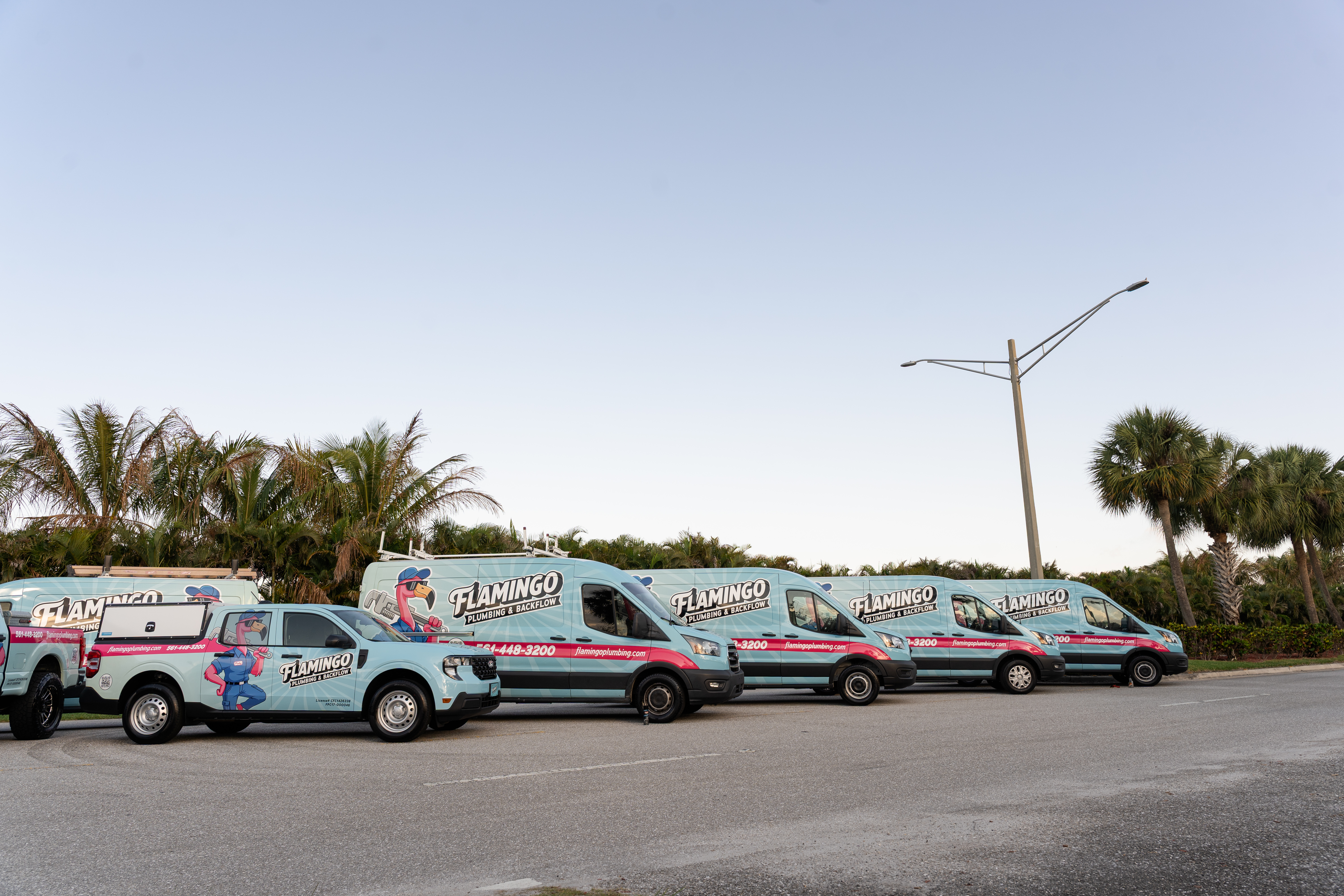Flamingo Plumbing service trucks lined up for dispatch